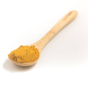 Curry powder into a teaspoon. measuring spoon on white background