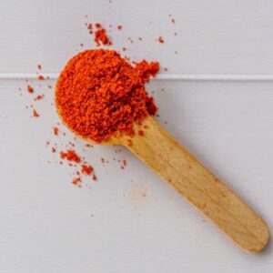 A top view of paprika powder in a wooden spoon