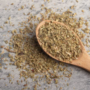 Oregano in wooden spoon on gray background
