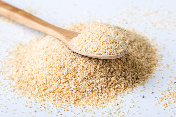 Garlic powder on white table with spoon