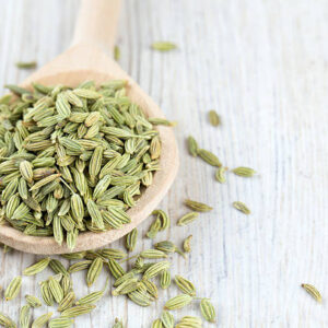 Fennel seed in a wooden spoon on table